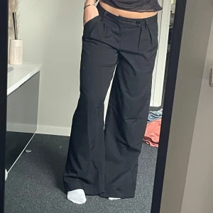 Lågmidjade kostymbyxor - Med knapp och fickor på baksidan