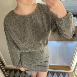 Glittrig klänning från Shein - Säljer en superfin glittrig klänning från Shein. Den är i en snygg silverfärg och har långa ärmar. Klänningen är tight och perfekt för festliga tillfällen. Även inga defekter och använd 1 gång❤️