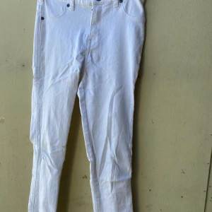 Vita jeans från Dr. Denim - Säljer ett par vita jeans från Dr. Denim. De är i en klassisk stil med fem fickor och knappgylf. Perfekta för en stilren look!