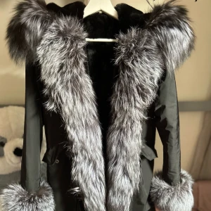 Parka svart och grå S/M - Jag säljer nu min parka då den inte kommer till användning. Jackan är i absolut nyskick! Inga fläckar eller hål. Äkta päls i ljusgrå/mörkgrå färg (pälsen runt luvan, armmuddarna och pälsen på jackans långsidor) storlek s/m.