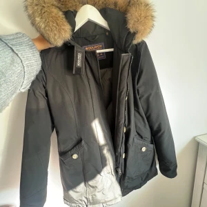 Woolrich jacka  - Woolrich arctic parka black  Köpt för 5500 på Zoovillage 💘🌟 Jackan är i fint skick dock endast ett slitage i armvecket som jag lagat själv, se bild Skulle gärna ha kvar den men den har blivit för liten för mig!  