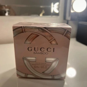 Gucci Bamboo Eau de Parfum - Säljer en lyxig Gucci Bamboo Eau de Parfum i en elegant rosa förpackning. Denna parfym är perfekt för den som älskar en sofistikerad och feminin doft. Förpackningen är helt ny och oöppnad, vilket gör den till en perfekt present eller tillägg till din egen samling. Köp nu och upplev den fantastiska doften av Gucci Bamboo!