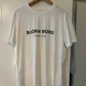 Vit t-shirt från Björn Borg - Säljer en stilren vit t-shirt från Björn Borg med texten 'BJÖRN BORG SINCE 1956' tryckt i svart på bröstet. Perfekt för en casual look, passar både till vardags och träning. T-shirten är i nyskick och har en normal passform.