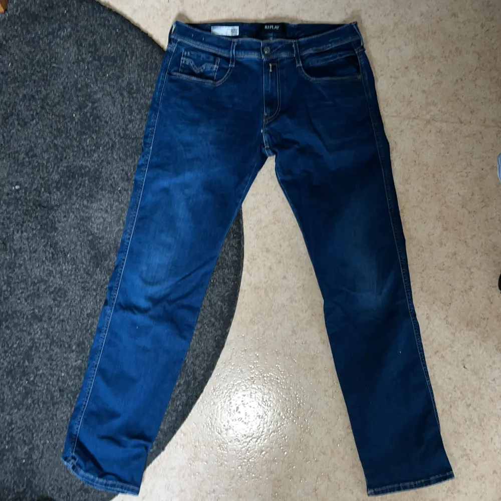 Säljer ett par snygga blå jeans från Replay, modell Anbass. De är i slim fit och storlek 34/30, vilket gör dem både bekväma och hållbara. Perfekta för både vardag och fest! Pris går att diskutera!. Jeans & Byxor.