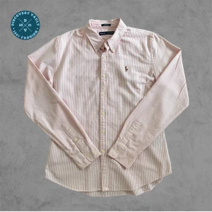 Ralph Lauren Randig Rosa Skjorta (skicka bud) -  Ge bud för snabb affär! En klassisk Ralph lauren Skjorta, perfekt för old money stil, Stockholmsstil, eller grish. Skriv gärna om mått och andra frågor!