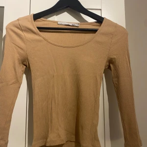 Beige topp - lager157  - Jättefin mörk beige urringad topp med lite rosa underton och skönt material. Toppen är ungefär trekvartsärmad och normal i storleken. Den är använd ett par gånger men är fortfarande i bra skick och har inga defekter. Pris kan diskuteras🤍