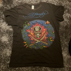 Ed Hardy T-shirt  - Jätte cool T-shirt från ed Hardy som tyvärr inte kommer till användning. Lite oklart vilken storlek det är men skulle gissa på XL. Typ grå/svart färg.  Skriv om ni har frågor.