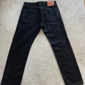 Svarta jeans från Levi's - LITE DAMMIGA PÅ BILDER MEN TAS LÄTT BORT MED RULLE GARANTERAT NYA Säljer ett par klassiska svarta Levi's jeans straight i nyskick. De har en snygg straight passform och är perfekta för både vardag och fest. Endast använda 2 gånger. Storlek W31 L30