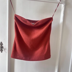 Röd ribbad tubtopp från Stockh LM Studio - Säljer en snygg röd ribbad tubtopp från Stockh LM Studio. Toppen har en stilren design med en mjuk och bekväm passform. Perfekt för sommardagar eller en kväll ute. Den är i storlek XS och i nyskick.