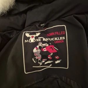 Svart dunjacka från Moose Knuckles - Säljer min Moose Knuckles den perfekt för kalla vinterdagar Jackan har en bra kvalitet och den är 1/1 använt den inte mycket bara 2 månader den e helt ny det finns inga trasiga saker och storlek är xxl men den passar som xl 100% priset kan diskutera