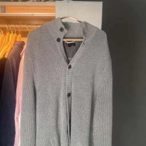 Stickad Cardigan med knappar  - Snygg grå tröja med knappar från dressman. Tröjan är i storlek L. Väldigt bra skick och perfekt till hösten och vintern! Tveka inte på höra av vid frågor!!