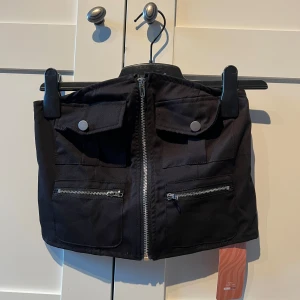 Svart kortkjol med dragkedja och knappar - Kjol & topp! Nya med prislapp kvar