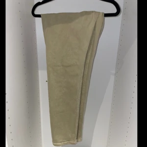 Beige byxor från Zara - Säljer ett par snygga beige byxor från Zara. De är i en klassisk stil med raka ben och en normal passform. Perfekta för både vardag och lite mer uppklädda tillfällen. Byxorna har praktiska fickor och är tillverkade i ett bekvämt material.