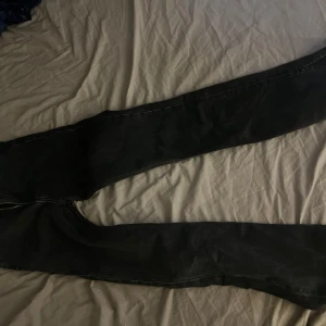 Svarta jeans från 157 - Snygga svarta jeans från 157 med klassisk design. De har en rak passform och är perfekta för en stilren look. Jeansen har fickor både fram och bak, vilket gör dem praktiska och bekväma. De är högmidjade samt utsvängda med slits.