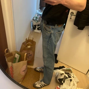 Levis byxor 32/34 - Säljer ett par klassiska blå jeansbyxor med normal passform. Byxorna har en rak stil och är midwaist. Perfekta för en avslappnad look.