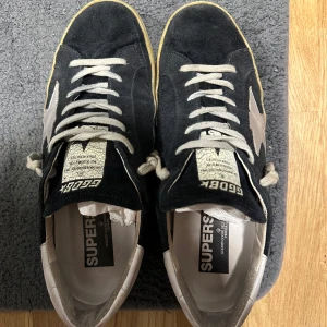 Golden goose skor  - Golden goose superstar skor, skicket är 8/10 förutom  heelbites där bak (normalt med dessa skor!), det är inga hål eller defekter på så sätt annars. Innermåttet är 28,5cm och storleken är 43 EU men passar även 43-44 EU. OBS! Endast skorna ingår! Fraktas spårbart!