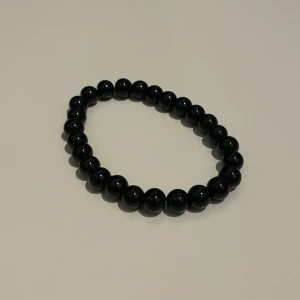 Svart pärlarmband - Elegant svart pärlarmband med glänsande runda pärlor. 
