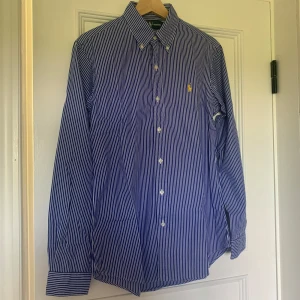 Blå och vit randig skjorta från Ralph Lauren - Hej, säljer denna skjorta från ralphlauren. Inga defekter och i toppskick. Tveka inte på att höra av dig vid funderingar! MVH Joel 
