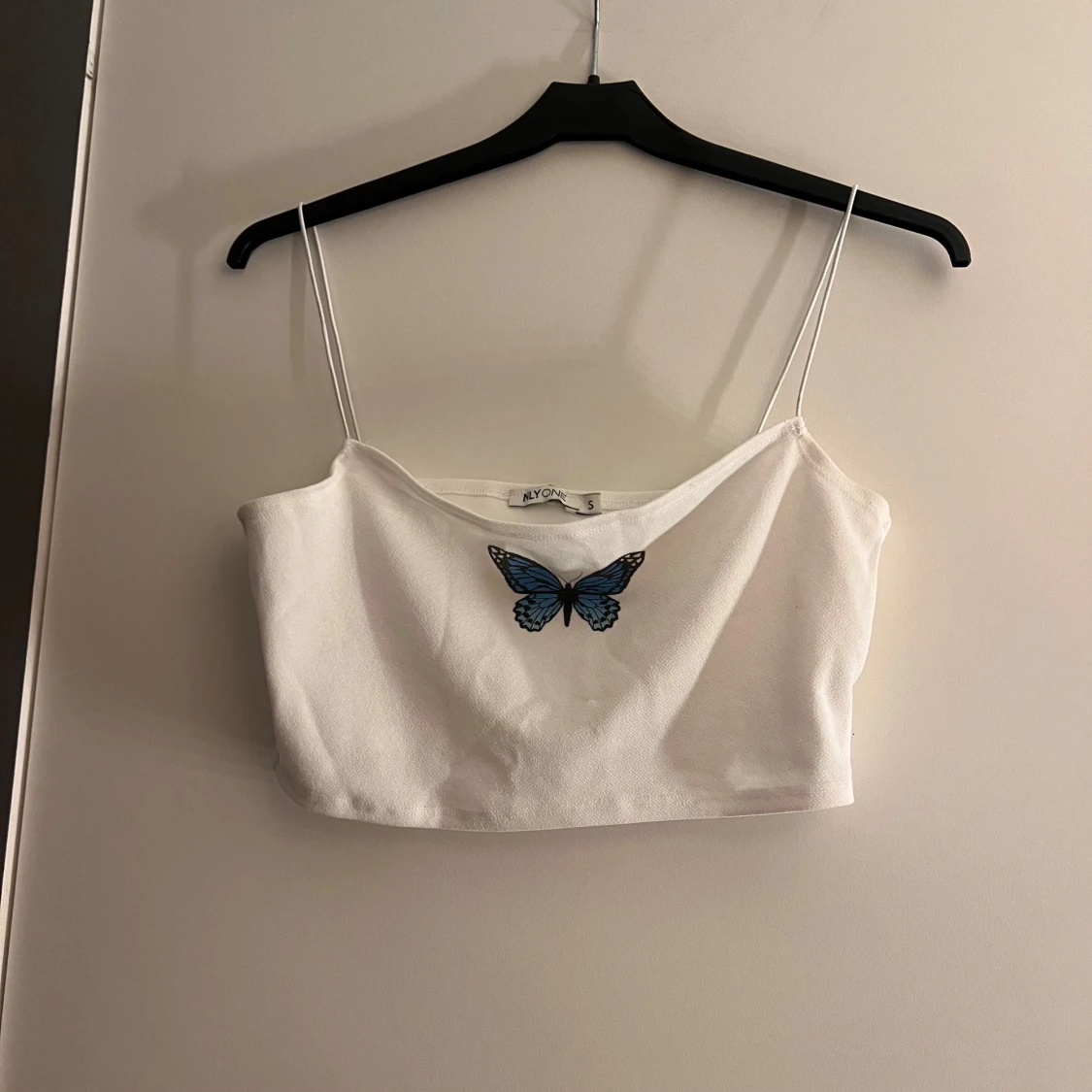 Vit linnetopp med fjärilsdetalj