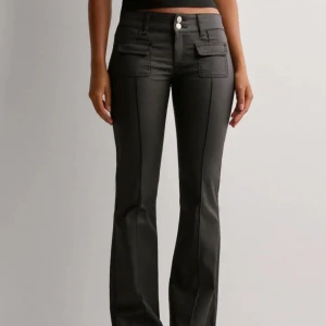 Svarta bootcut byxor med fickdetaljer - Helt nya low waist svarta bootcut jeans från Nelly!! Aldrig använda men ingen prislapp och säljer pga fel storlek💕💕storlek 36 och nypris 700kr!