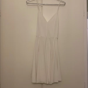 Vit klänning / Studentklänning  - Säljer en stilren vit klänning från Bik Bok i storlek XS. Klänningen har smala axelband och en v-ringad design framtill. Perfekt för sommarens alla tillfällen. 💫