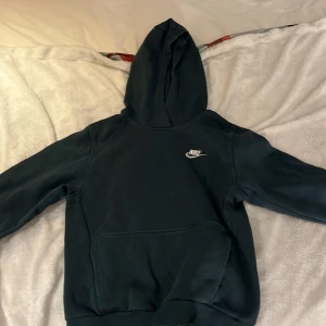 Mörk grön hoodie från Nike - Säljer mörk grön hoodie från Nike med broderad logga på bröstet. Aldrig använd. Storlek 147-158cm