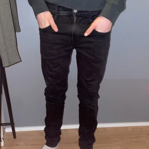 Svarta jeans från Replay - Snygga svarta jeans från Replay med en tight passform. De har en klassisk femficksdesign och en dragkedja med knapp framtill. Perfekta för en stilren look.