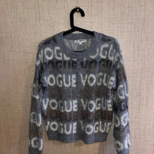 Grå tröja med VOGUE-text från Just Cavalli - Snygg grå tröja från Just Cavalli med VOGUE-text i olika nyanser. Tröjan har en normal passform och långa ärmar, perfekt för en trendig look. Den är tillverkad i ett mjukt material som ger en skön känsla. 