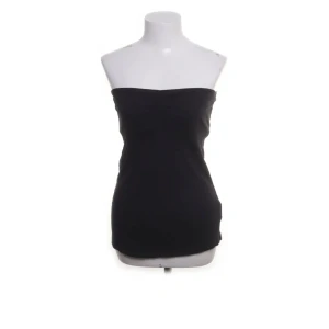 Svart tubtopp från Tally Weijl - Snygg svart tubtopp som passar perfekt för en stilren look. Den är enkel och elegant, vilket gör den lätt att matcha med olika outfits. Perfekt för varma dagar eller som ett basplagg i garderoben.