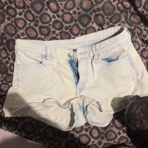 Ljusblå jeansshorts - Snygga ljusblå jeansshorts med låg midja och klassisk femficksdesign. Perfekta för varma sommardagar. De har en knapp och dragkedja framtill för enkel på- och avtagning.