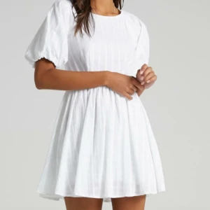 Studentklänning  - Superfin vit miniklänning med öppen rygg från showpo. Passar perfekt till studenten, säljer då jag valde en annan klänning. Den är enbart testad så har lapparna kvar. Storlek M men liten i storlek så passar även S.