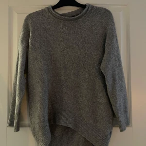 Grå stickad tröja från H&M - Mysig grå stickad tröja från H&M. Enkelt att matcha med olika outfits. 