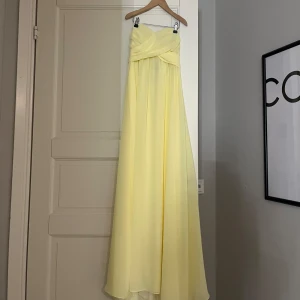 Gul axelbandslös långklänning - En simpel men skit snygg sommar eller även balklänning.