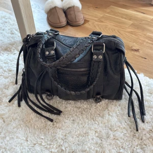 Svart skinn handväska med flätade handtag - Väskan är väldigt elegant och har många fina fickor. Väskan är i mycket bra skick och har varit väl omhändertagen.