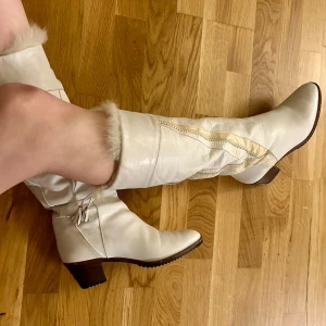 Vita vinterstövlar - Snygga vita stövlar med päls inuti och cowboy detaljer på utsidan. Köpta vintage och tyvärr blivit lite för små för mig. Storlek 39 men liten i storleken 💞