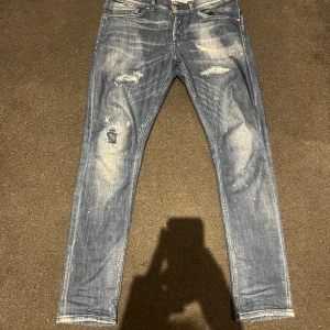 Dondup - Säljer dessa Domdup jeansen i grymt skick. De har en klassisk femficksdesign och är perfekta för en avslappnad stil. Passformen är slim fit och de har en dragkedja och knapp framtill.