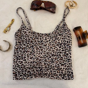 Leopardmönstrad linnetopp - Trendig leopardmönstrad linnetopp med smala axelband. Perfekt för en djärv och stilren look. Passar utmärkt till både jeans och kjol.