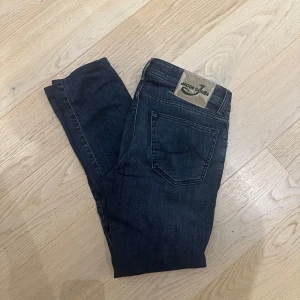 Jacob Cohen jeans - Snygga mörkblå jeans från Jacob Cohën med klassisk femficksdesign och knappgylf. Perfekta för en stilren look. Märkesdetaljer på baksidan ger en exklusiv touch.