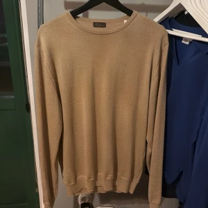 Beige tröja från Stenströms - Säljer en stilren beige tröja från Stenströms.tröjan är i storlek L men  Den är mindre i storleken har själv m och s i mina tröjor och den passar. Tröjan har en klassisk rund hals och långa ärmar, perfekt för en elegant och avslappnad look. Passar bra till både vardag och mer uppklädda tillfällen. Det är 100 merino ull och använder samma ull som lyx märket  zegna. Tröja är nästintill helt ny och sicket är 9/10. Skriv över funderingar.