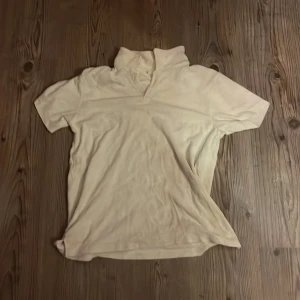 Beige kortärmad tröja från Kappahl - Säljer en beige kortärmad tröja från Kappahl i storlek 158/164. Tröjan är tillverkad av 80% bomull och 20% polyester, vilket gör den mjuk och bekväm. Perfekt för en avslappnad stil.