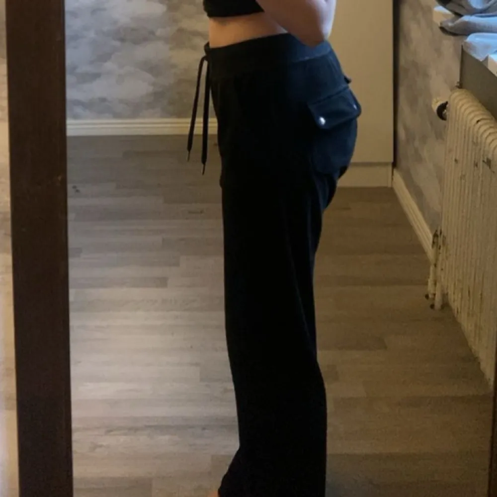 Snygga svarta mjukisbyxor från Juicy Couture med hög midja och en loose passform. Byxorna har praktiska fickor med knappar och snörning i midjan för extra komfort. Perfekta för en avslappnad stil. Jag är 170 ich och dom är lite långa, sann till storleken. Betalning sker via swish, mer info kan man adda min snap:nova.202 eller skriva här på plick☺️. Farkut & Housut.