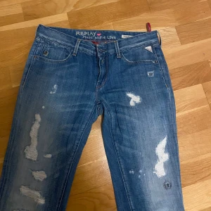 Blå jeans från Replay - Snygga blå jeans från Replay med slitna detaljer och en klassisk femficksdesign. Låg midja och ganska utsvängda! Perfekt för dig som gillar att ha trendiga byxor på dig! Det är från sellpy och har inte använt de, då jag tyckte de var lite små i midjan på mig. Skriv ifall ni har några frågor.💕köpte de för 400