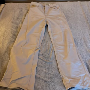 Beige byxor från H&M Divided - Snygga beige byxor från H&M Divided med en klassisk design. Byxorna har en rak passform och är tillverkade i ett bekvämt material. Perfekta för en stilren look.