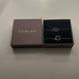 Silverfärgat Infinity halsband och armband från Edblad - Aldrig använt då den köptes oanvänd från Plick och sen aldrig använd av mig. Om ni bara vill köpa ett av smyckena så kan ni kontakta mig