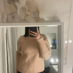 Rosa stickad tröja - Mysig rosa stickad tröja med långa ärmar och ribbade muddar. Perfekt för kyligare dagar.