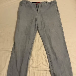 Replar X Hugo Boss - Snygga ljusblå jeans från Hugo Replay med klassisk femficksdesign. De har en rak passform och är tillverkade i ett bekvämt denimtyg. Perfekta för en avslappnad men ordentlig stil!