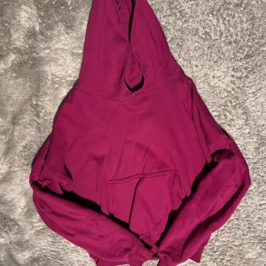 Vinröd hoodie YZY - Säljer en snygg vinröd hoodie från YZY. Den har en klassisk design med en stor huva och en praktisk magficka. 67cm längd, 80cm ärm 72cm axelbredd.