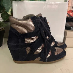 Fina kilklackar  - Snygga skor från märket ash, dessa liknar de populära isabel marant skorna. De är guldiga och mörkblå 