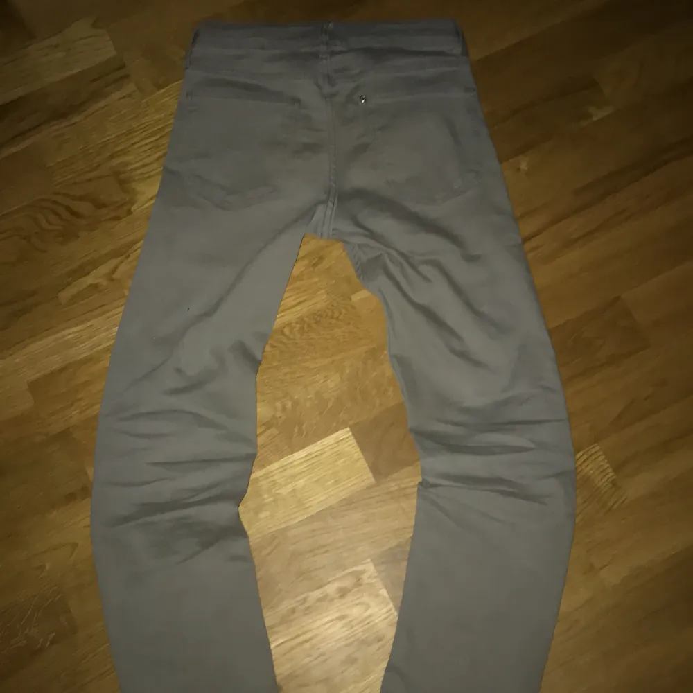 Säljer ett par grå slim fit byxor från H&M med justerbar midja. Perfekta för en stilren look och bekväma att bära. Passar för barn i åldern 10-11 år.. Jeans & Byxor.