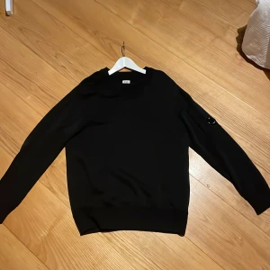 Svart tröja från C.P. Company - Säljer en stilren svart tröja från C.P. Company. Är i mycket bra skick ser helt ny ut inga defekter. Nypris 1800kr. Priset kan diskuteras!😄
